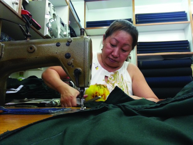 Routine familiarity: Madam Poh skillfully works on trimming a pair of pants down to size. Photo Credit: Adele Lee