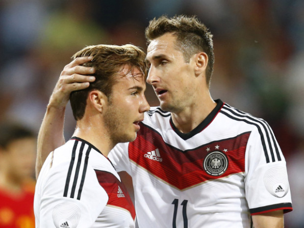 PASSING THE BATON: 36-year-old Miroslav Klose (right) embraces 22-year-old Mario Gotze, his replacement, who went on to score the winning goal to give the German legend a resounding send-off in what will surely be his final World Cup appearance. (Photo: Ralph Orlowski/Reuters)