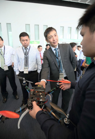 INVENTIONS GALORE: The guest-of-honour at Tech Day, Health Promotion Board CEO Zee Yoong Kang (centre), looks at a prototype of an Unmanned Aerial Vehicle (UAV) for the medical sector, as part of a start-up project done by engineering students, at the Centre for Enterprise and Communication booth. (Photo: Organising Committee of Tech Day 2014)