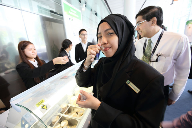 YUMMY BUT HEALTHY: A staff eats ice-cream enriched with prebiotic and probiotics (in chocolate and vanilla flavours) at the School of Applied Science's Functional Ice-cream project booth. (Photo: Organising Committee of Tech Day 2014)