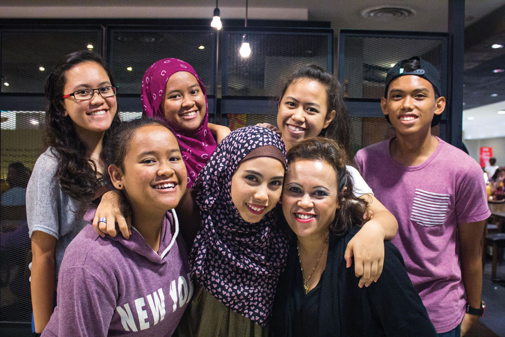 CLOSE KNIT FAMILY: Even though there are many ups and downs, Syaidah (front row, centre) and her family always put on a smile. Their happy demeanor makes everyone around them feel welcome. Photo: Nur Hidayah Roslan
