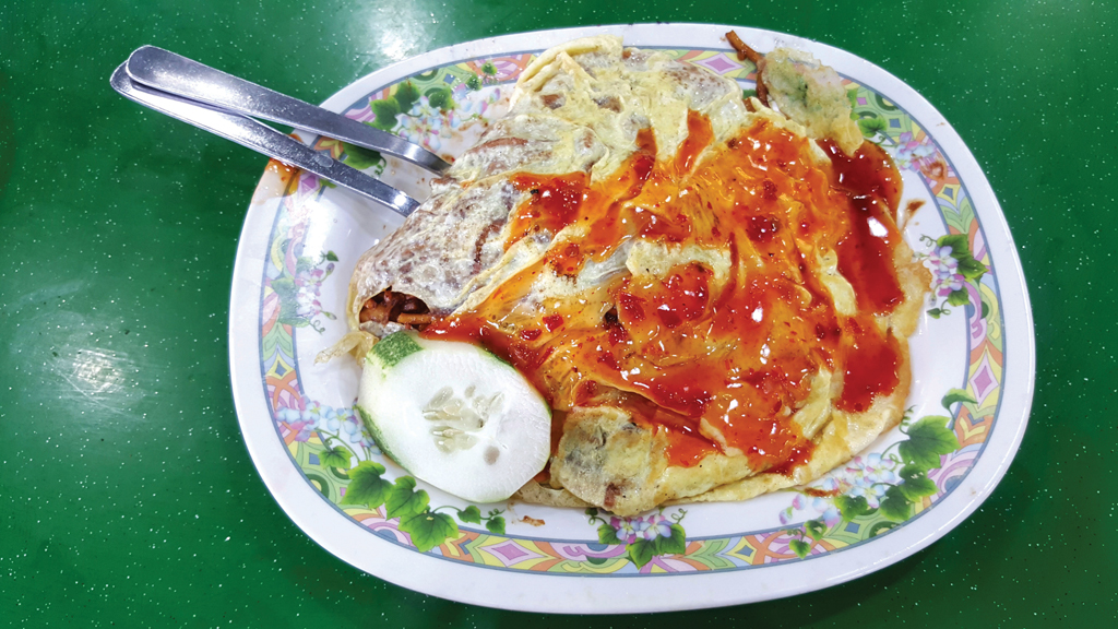 Hearty Meal: The mee goreng pattaya has yellow noodles buried in a warm fried egg duvet.