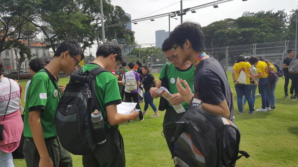 DISCUSSION IN PROGRESS: Before setting off from their base camp outside Victoria Memorial Hall, students from Woodlands Ring Secondary gather and put their heads together to discuss their game plan. (Photo: Yeow Chin Chin)