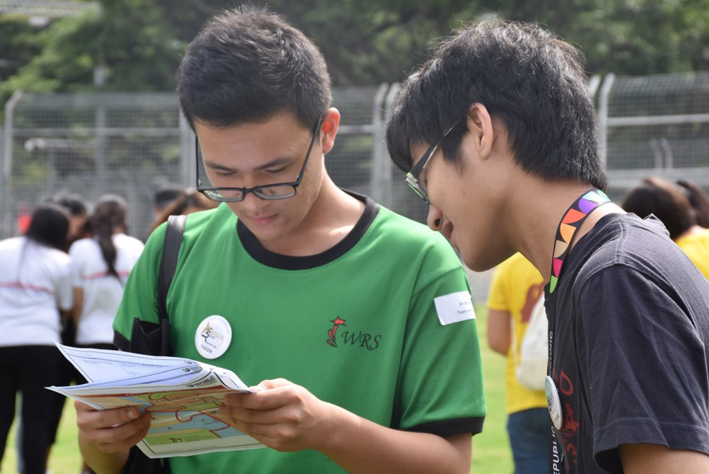 STRATEGY IS KEY: A common sight during the race, groups stayed around the meeting point to figure out their game plan. Clues need to be solved before they can go to the various locations to complete the challenges. (Photo: Maisha Samiha)  